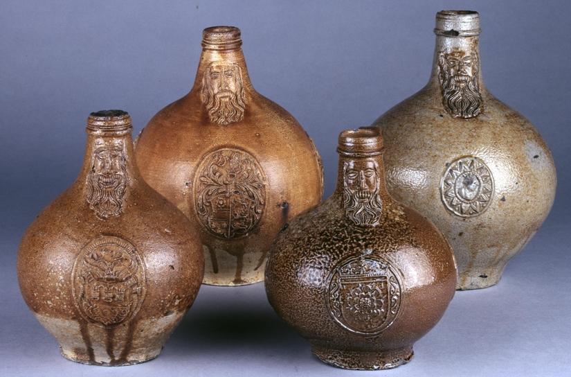Four bartmann jugs of different sizes. Each has a bearded face and a round body