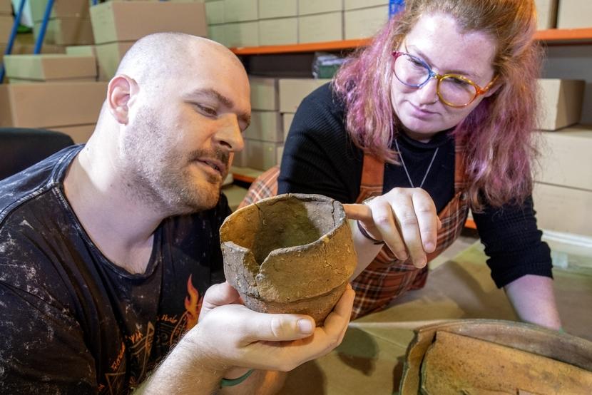 Archaeologists from MOLA Northampton looking at a Bronze Age urn