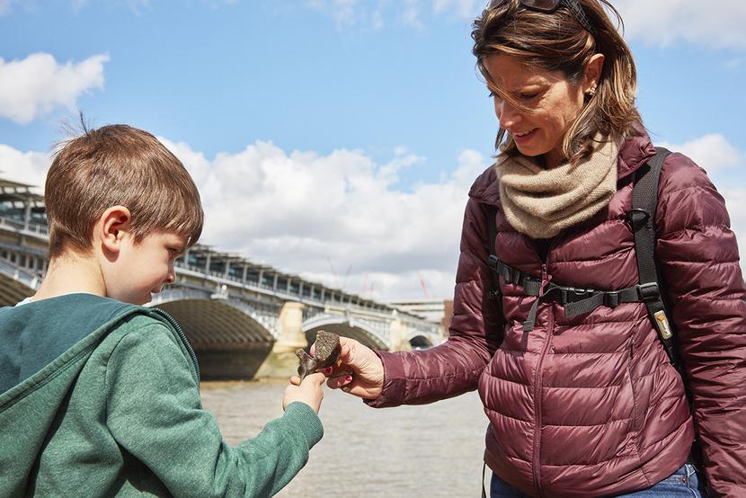 An adult and child explore the River Thames foreshore