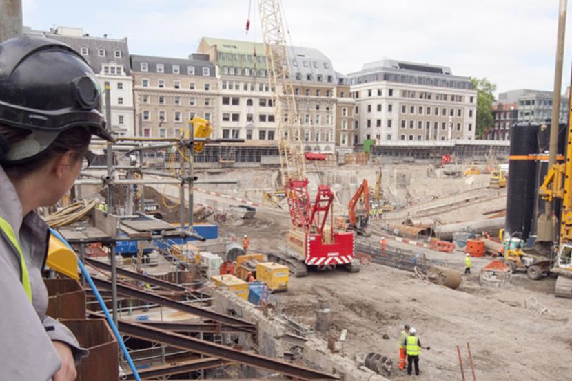 An archaeologist in PPE looks over an urban archaeological site