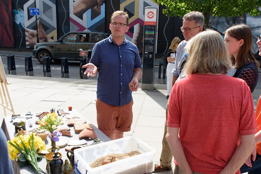 Members of the public listen to an archaeologist talking about a site