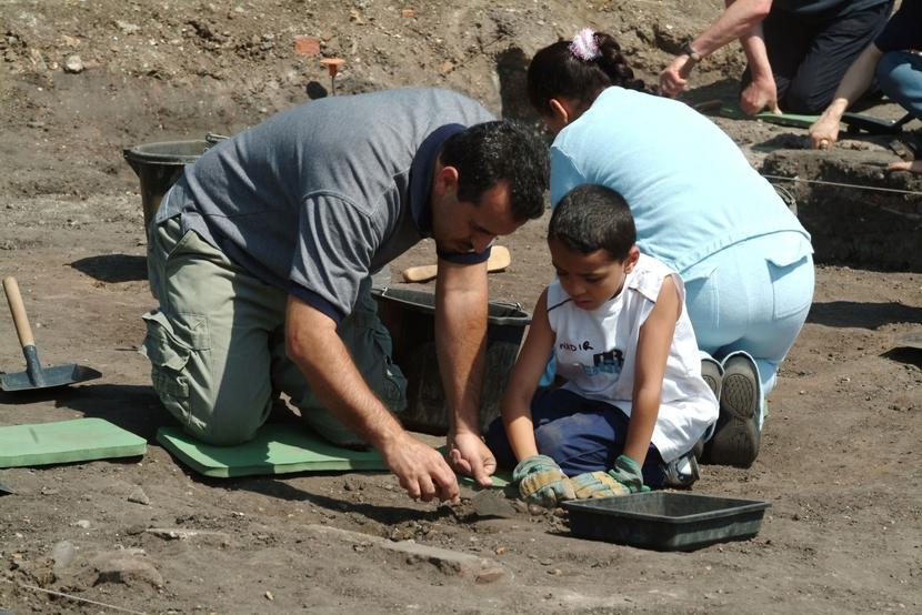 a man and child excavating a site together as part of a community dig