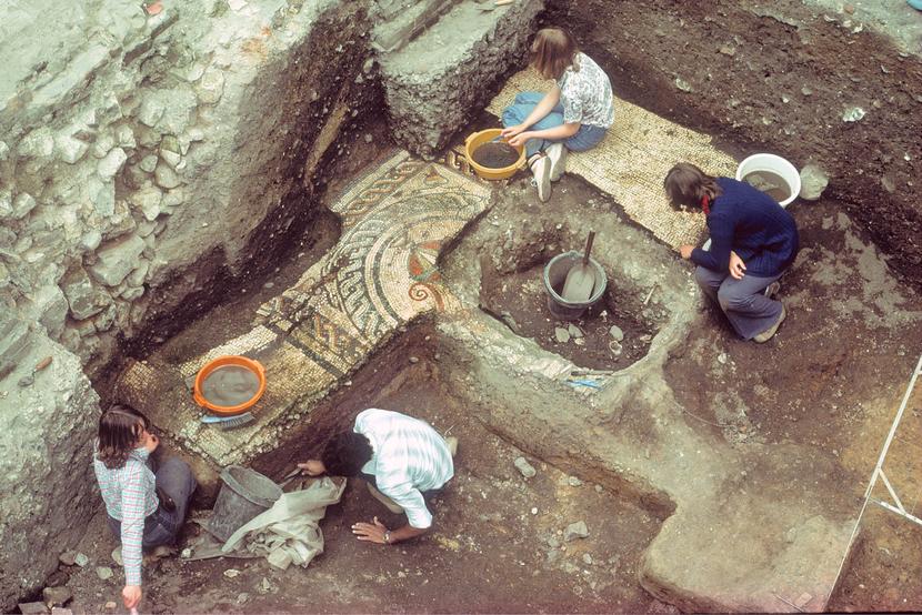 An old photo of a group of archaeologists excavating a Roman mosaic.