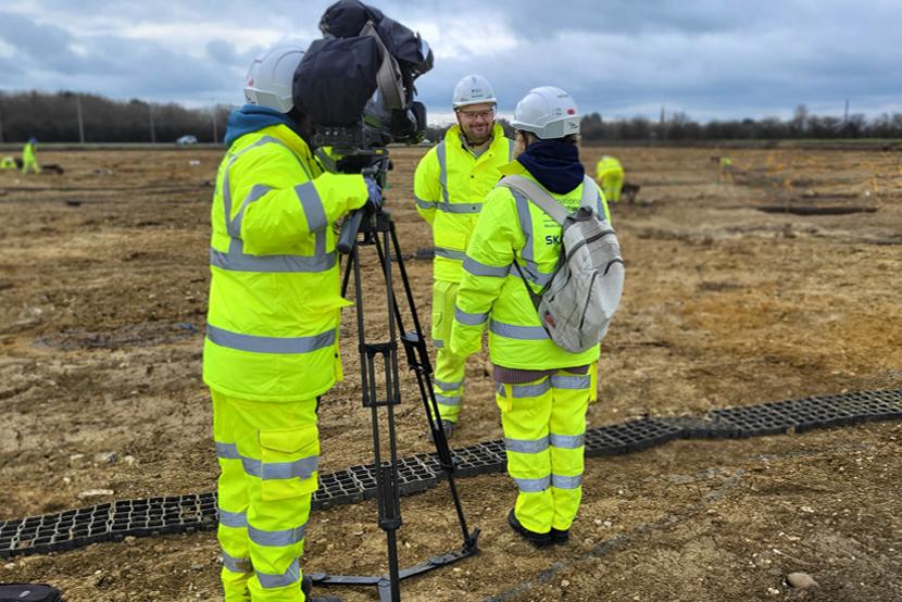 A member of the MOLA team being interview on site by a TV news crew.