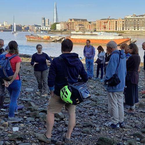 People on a guided walk look on as an archaeologist explains the history of the site