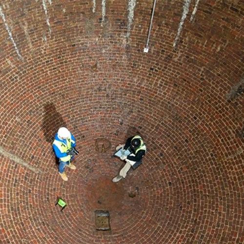 Archaeologists record the inside of a large brick icehouse