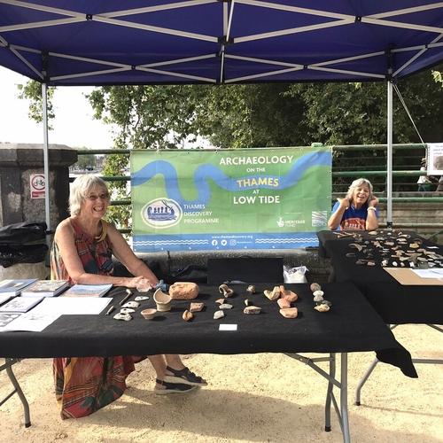 Two people sat at a table with archaeological finds