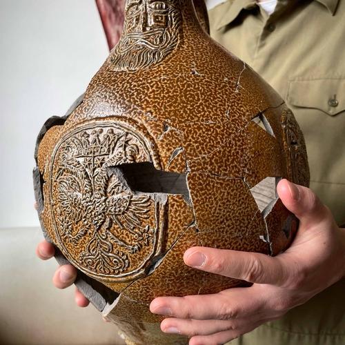 Hands holding a large reconstructed Bartmann jug