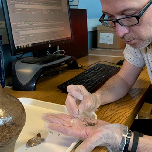 Archaeologists looks at a witch bottle