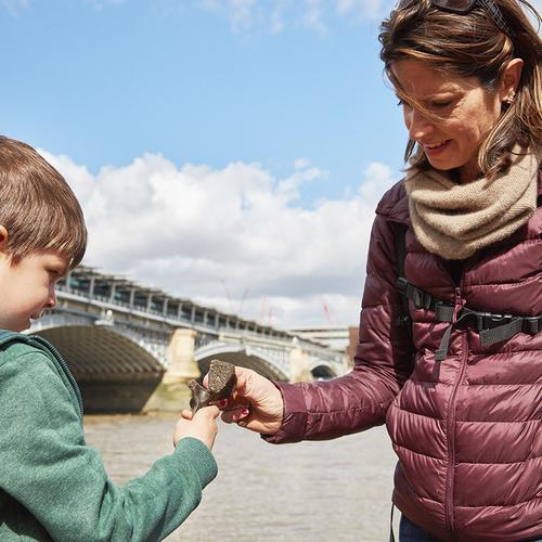 An adult and child explore the River Thames foreshore